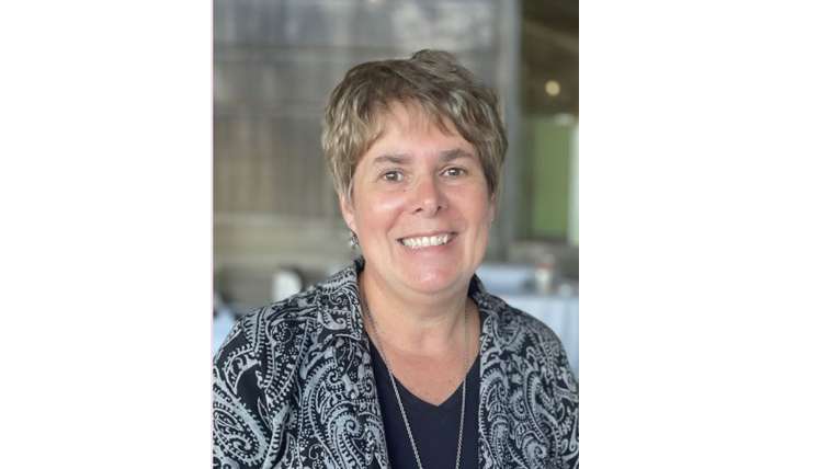 Kim Fenn Kim Fenn, Medical Assistant and Operations Manager for Full Circle America (FCA) wearing and black and white jacket over a black shirt with short blond hair